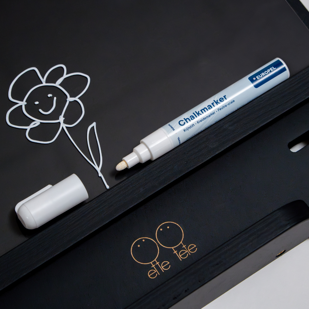 Detail van het tekenbord met een bloemtekening en witte krijtstift
