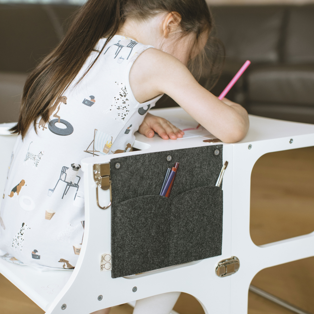 Kind zit te tekenen aan de Houten Learning Tower 2in1 wit met potloden in zijvak