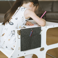 Kind zit te tekenen aan de Houten Learning Tower 2in1 wit met potloden in zijvak