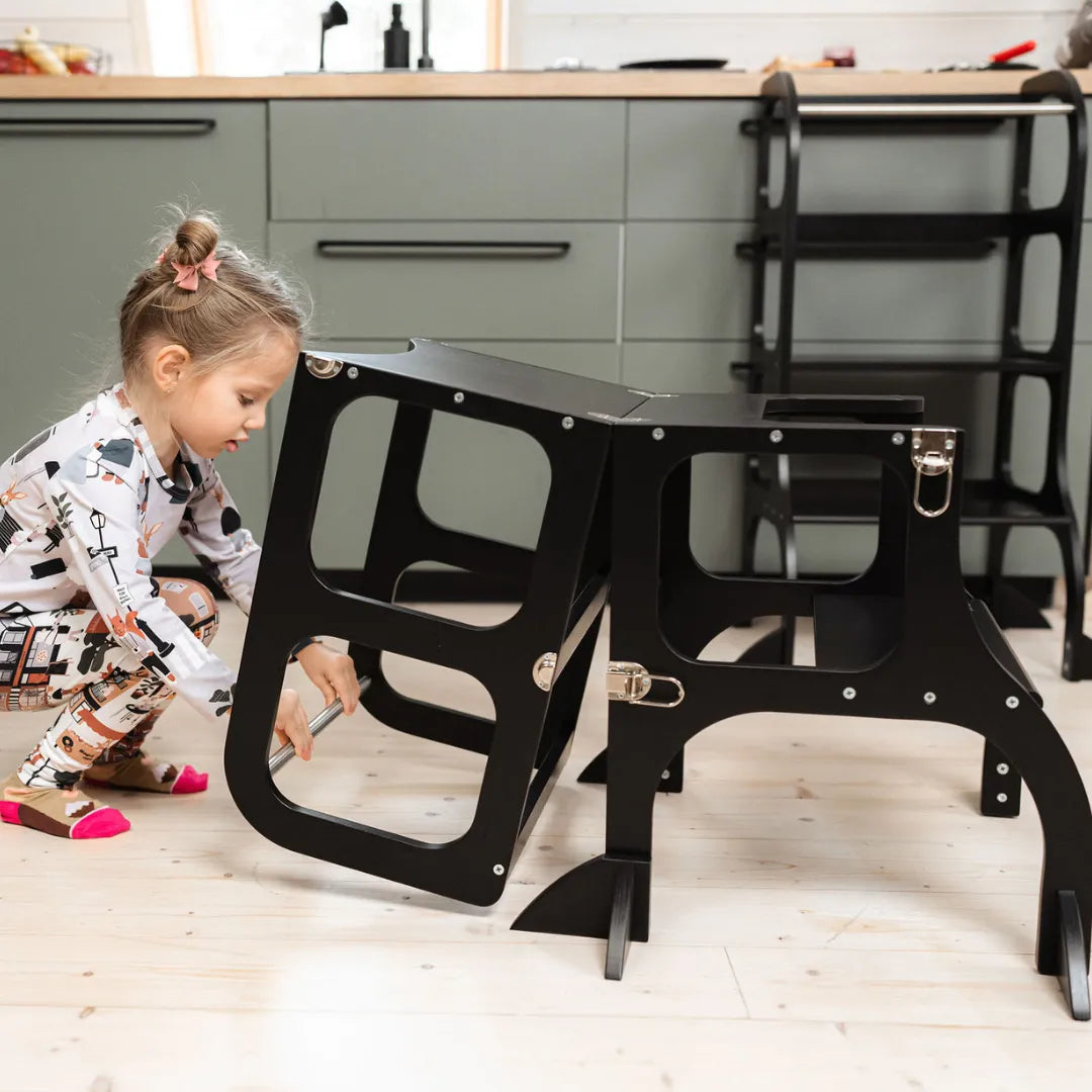 Kind speelt met Houten Learning Tower 2in1 - zwart in moderne keuken omgeving