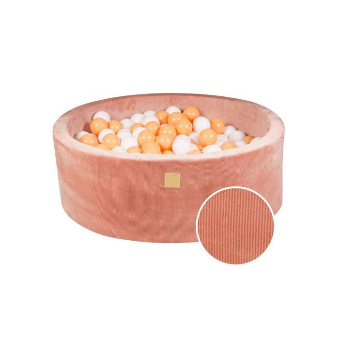 Zalmroze ronde ballenbak met witte en oranje ballen, inzet toont ribstof