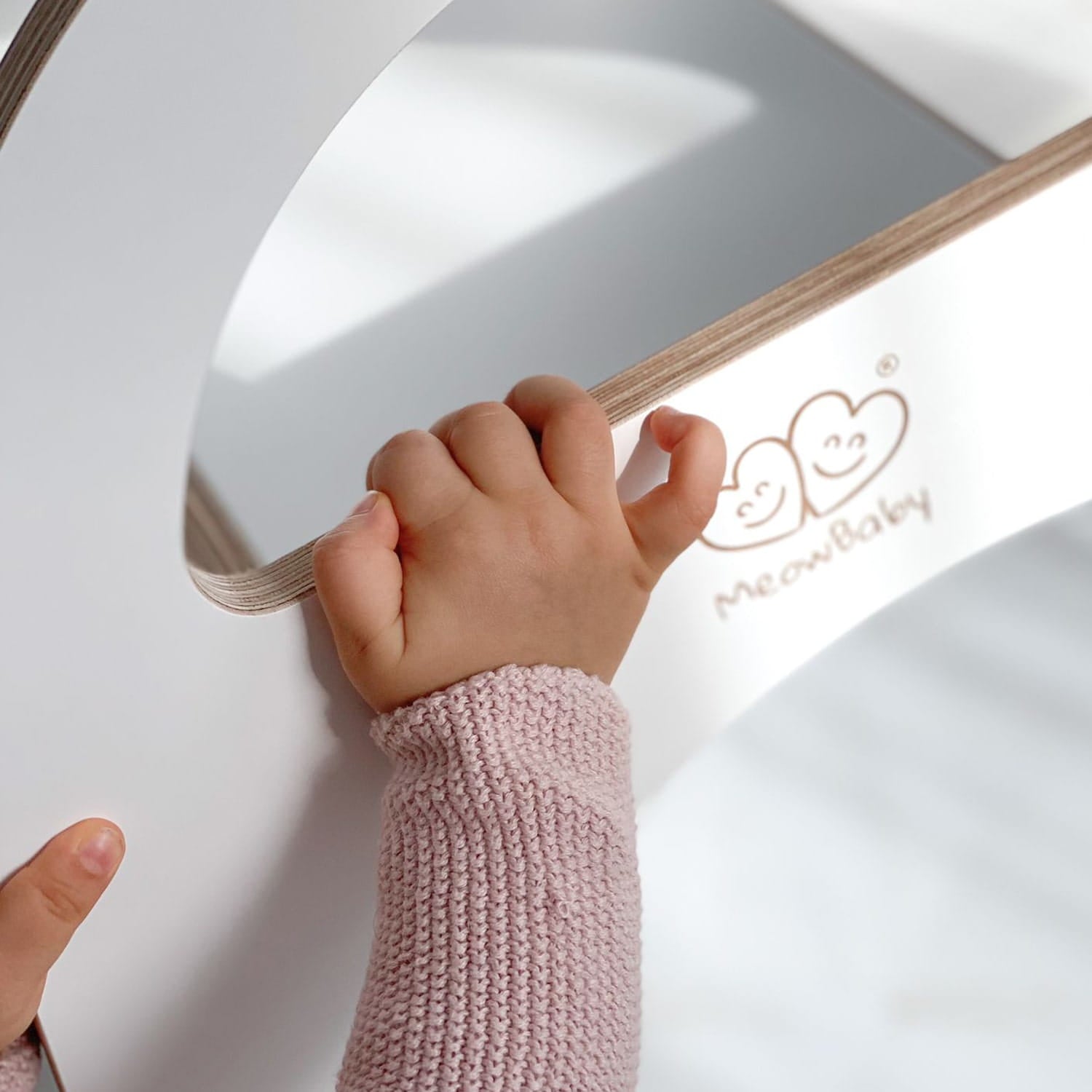 Handje van een kind pakt de Houten indoor glijbaan voor binnen spelen veilig vast