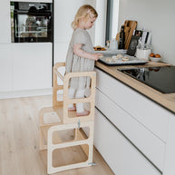 Kind gebruikt Montessori Houten Learning Tower 2in1 om veilig te bakken in de keuken