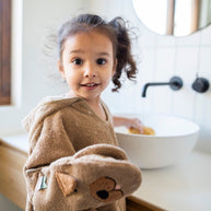 Kind draagt Bad Poncho - Mr. Dog in badkamer met vrolijke uitstraling aan wasbak