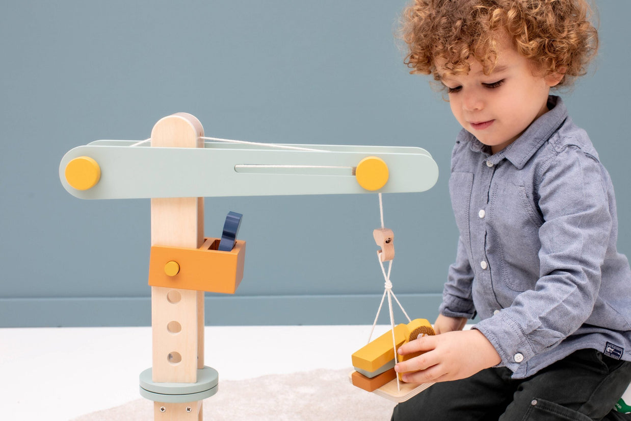 Jongen speelt met Trixie Houten Kraan, bouwspeelgoed met dieren en blokken voor creatief spel
