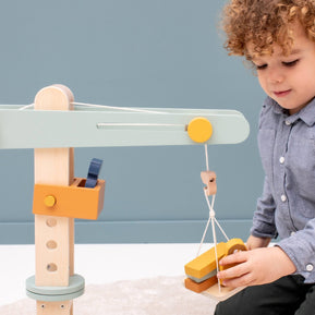 Jongen speelt met Trixie Houten Kraan, bouwspeelgoed met dieren en blokken voor creatief spel