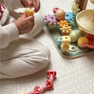 Kind speelt met Houten Activiteitenboom 4 in 1 - Knikkerbaan, Vormenstoof, Tandwiel en Kralenlabyrint