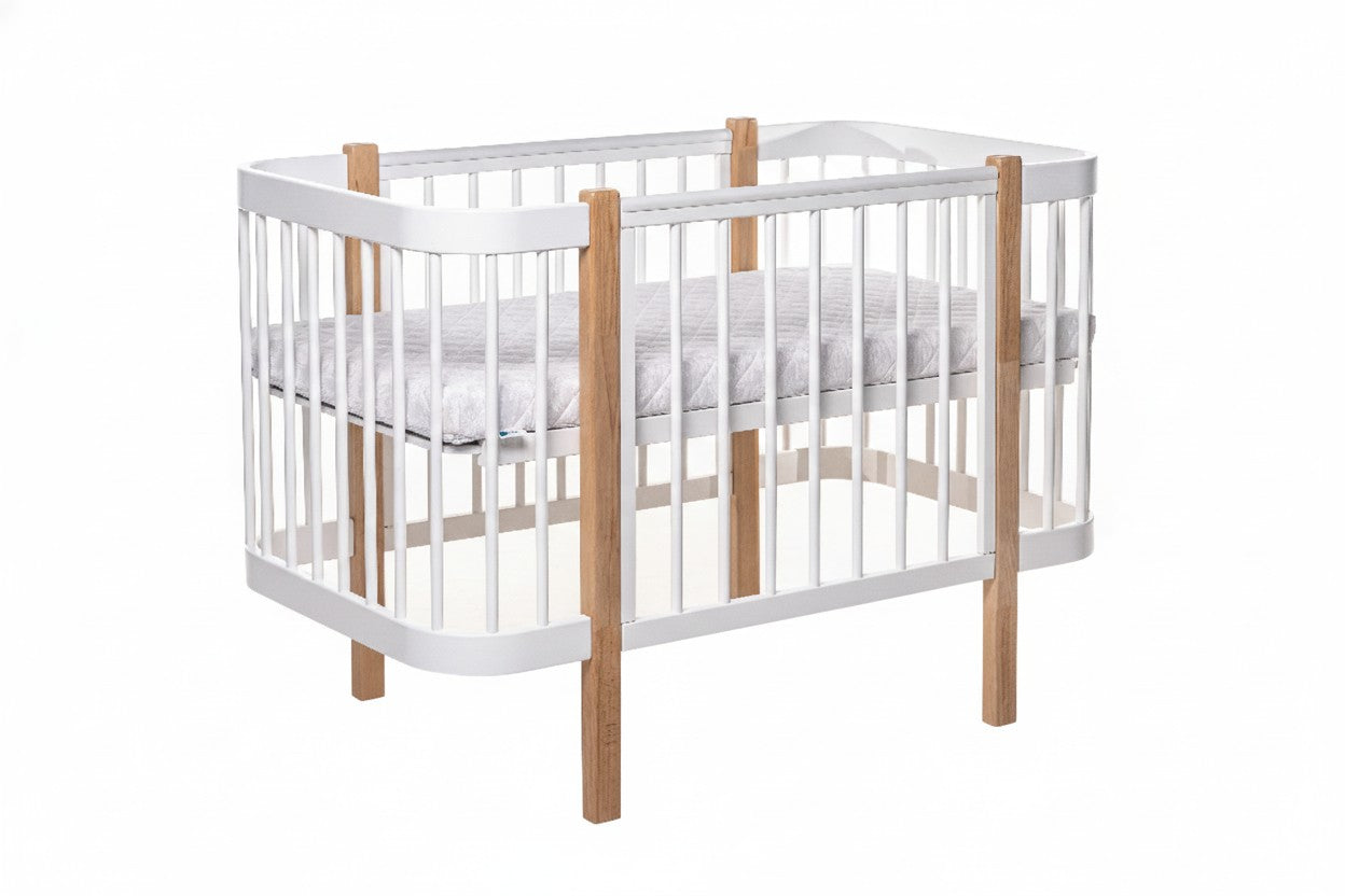 Naturel-wit ELIN babybed van beukenhout met witte spijlen, schuin vooraanzicht