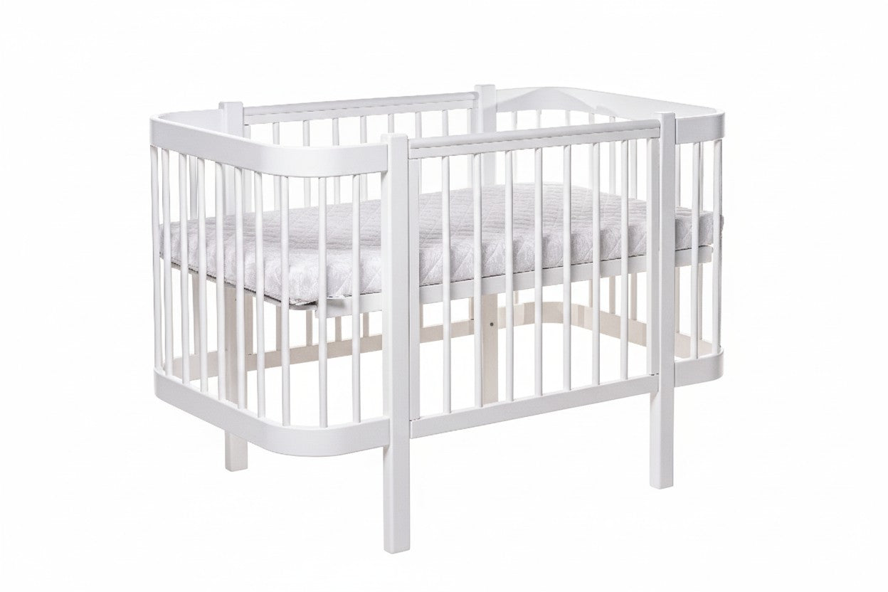 Wit ELIN babybed met verstelbare bodemhoogte, zijaanzicht op witte achtergrond