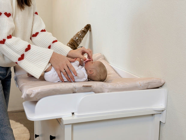 Family-scl Verschoonmat gebruikt voor babyverzorging op een commode in een huiselijke omgeving