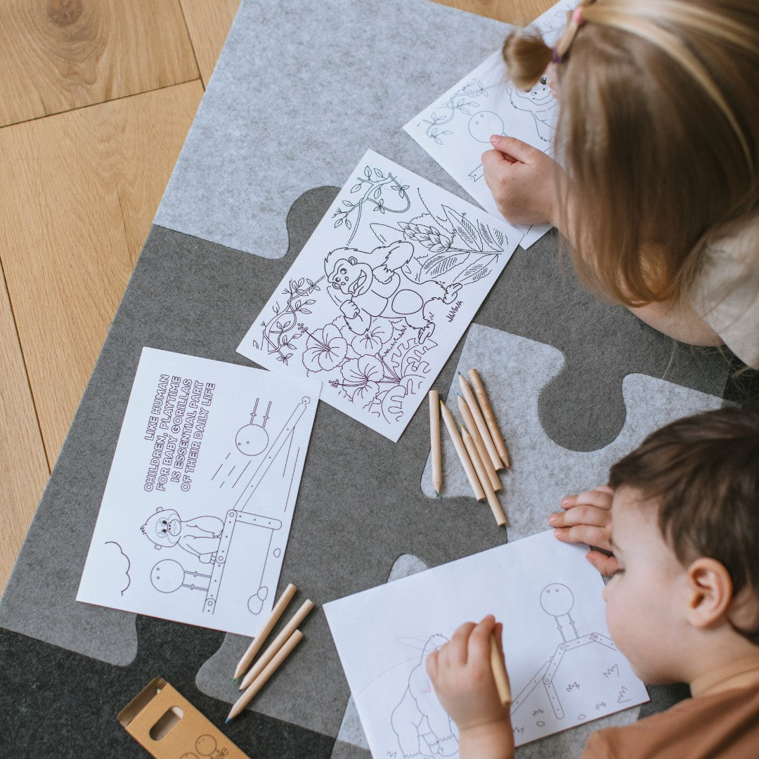 Twee kinderen kleuren liggend op de vilten puzzel-speelmat