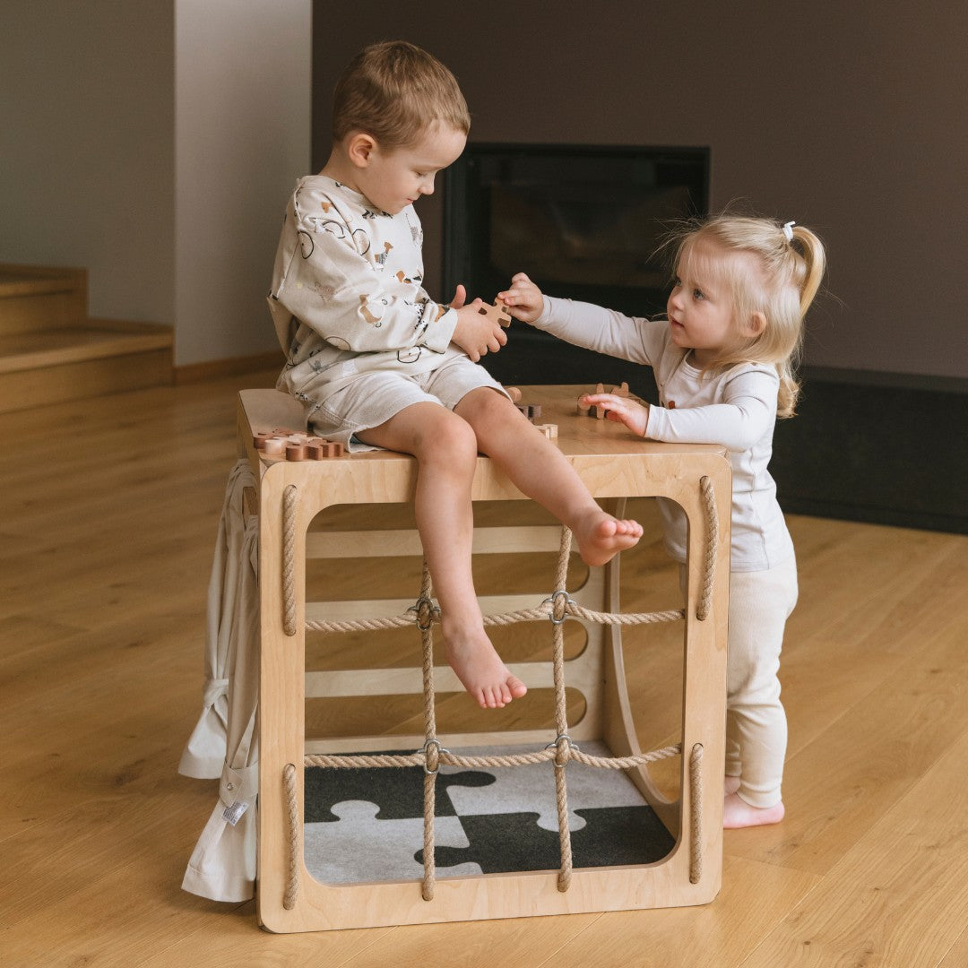 Twee kinderen spelen bij het klimtoestel met de vilten puzzel-speelmat eronder
