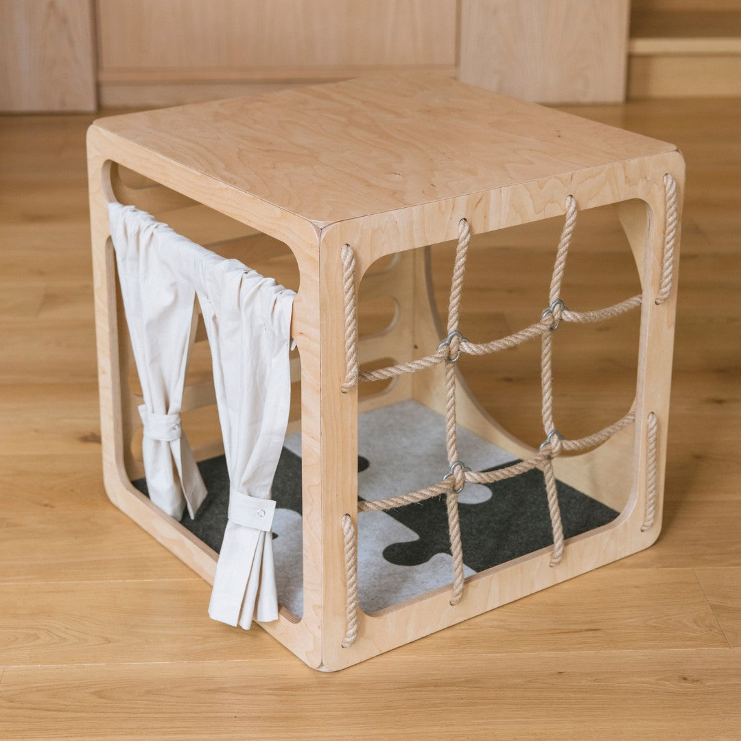 Houten klimkubus met de vilten puzzel-speelmat op de bodem