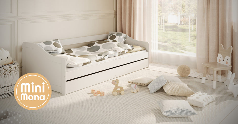 Kinderkamer met wit bed, zachte kussens en speelgoed op een lichte vloer