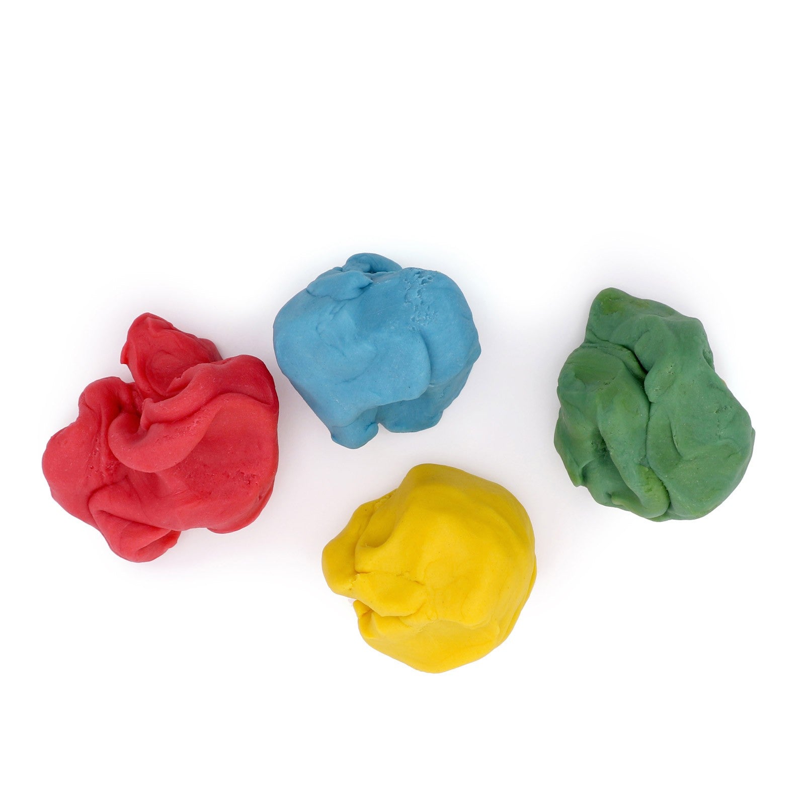 Vier gekneedde klompjes biologische klei in rood, blauw, groen en geel
