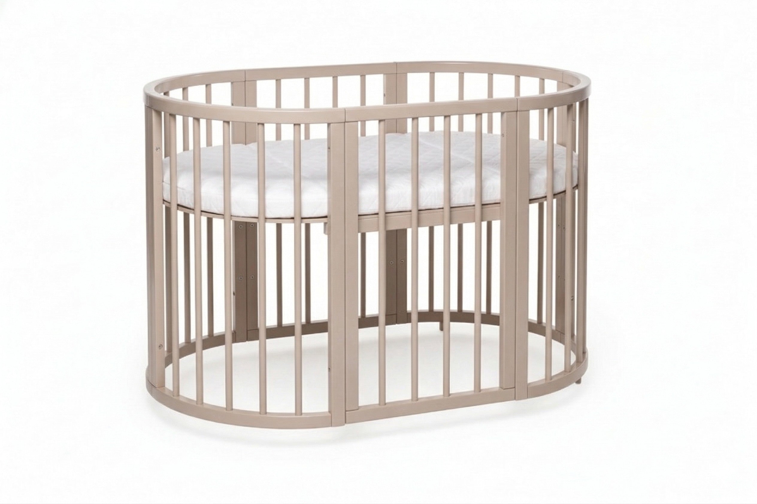 Ovaal houten babyledikant Olin in cappuccino met matras op studioachtergrond