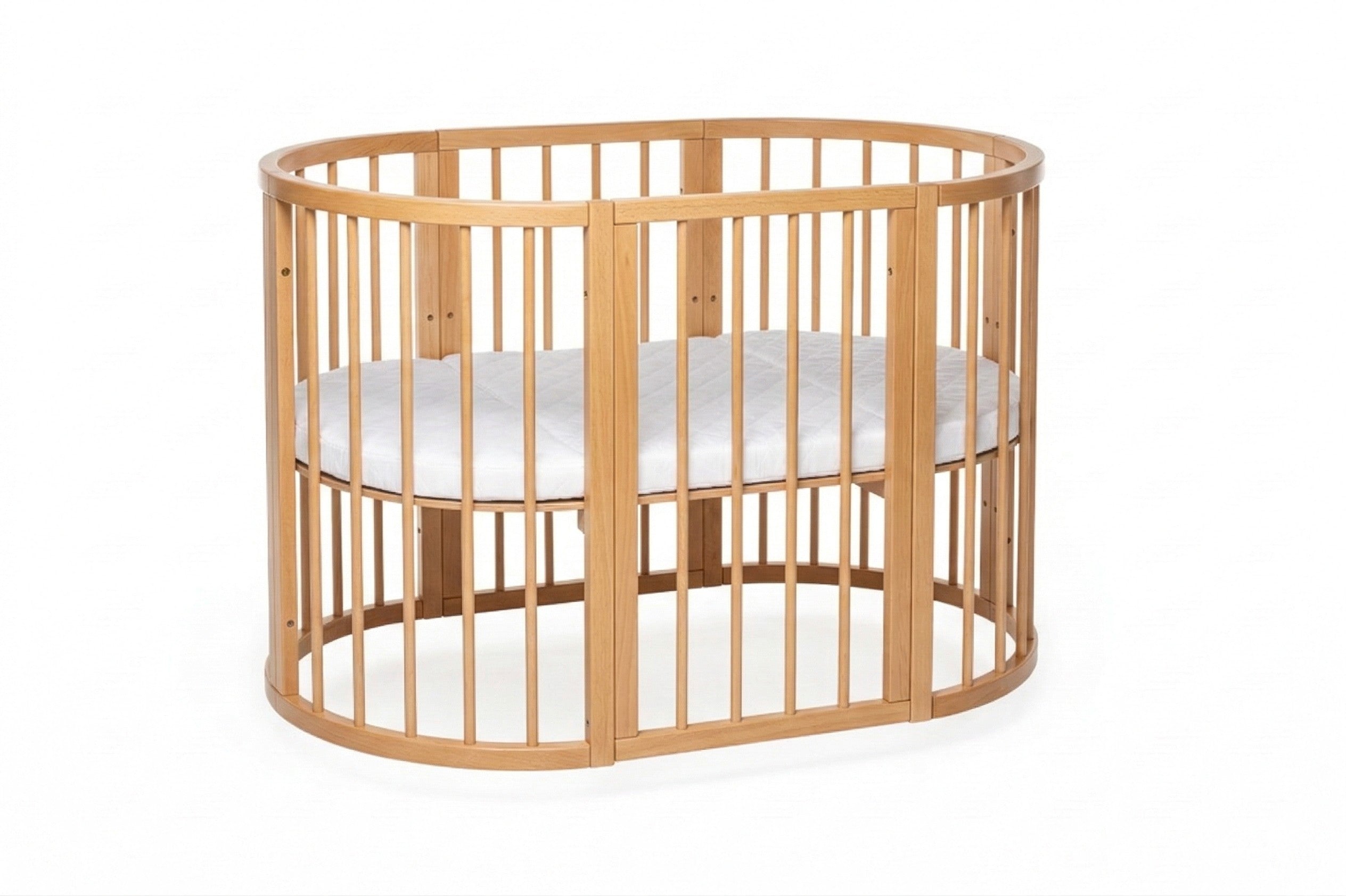 Ovaal houten babyledikant Olin in natural met witte matras op studioachtergrond
